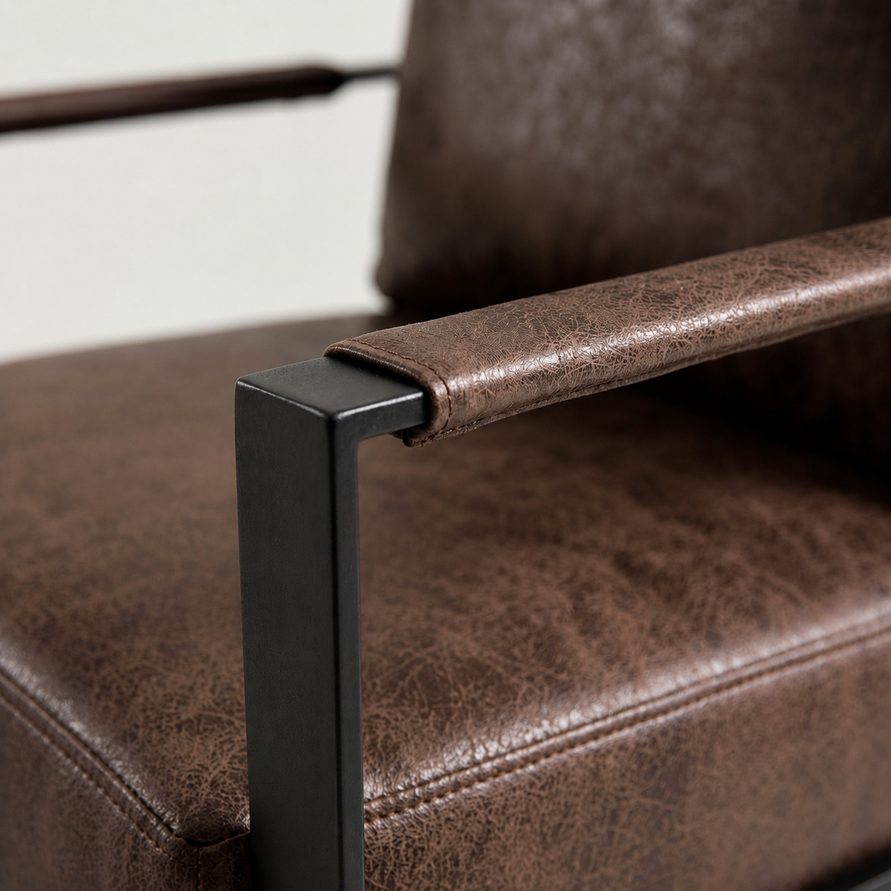 Padded armrest close-up chocolate microfiber texture black metal joint