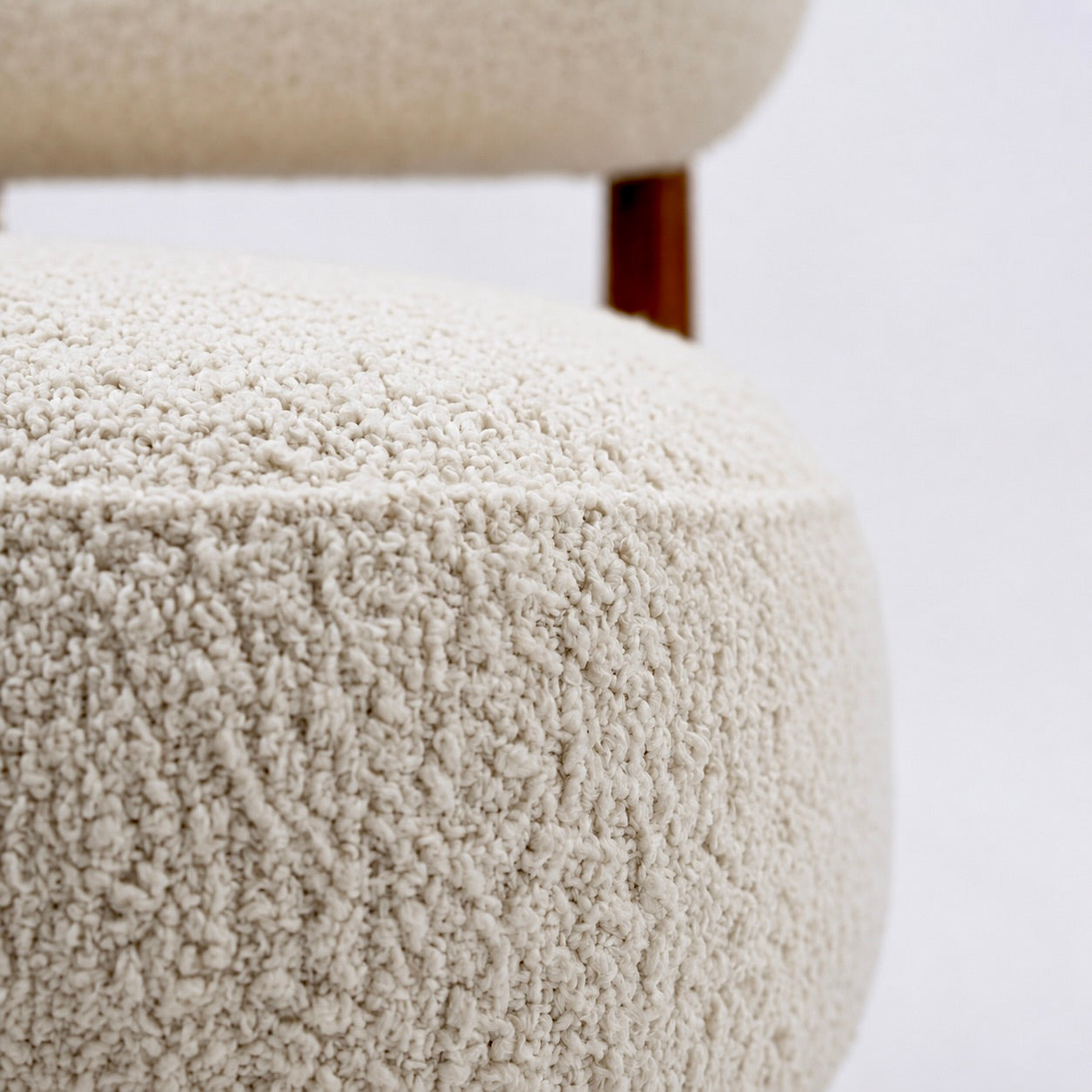 Ivory boucle fabric texture close-up plush accent chair upholstery