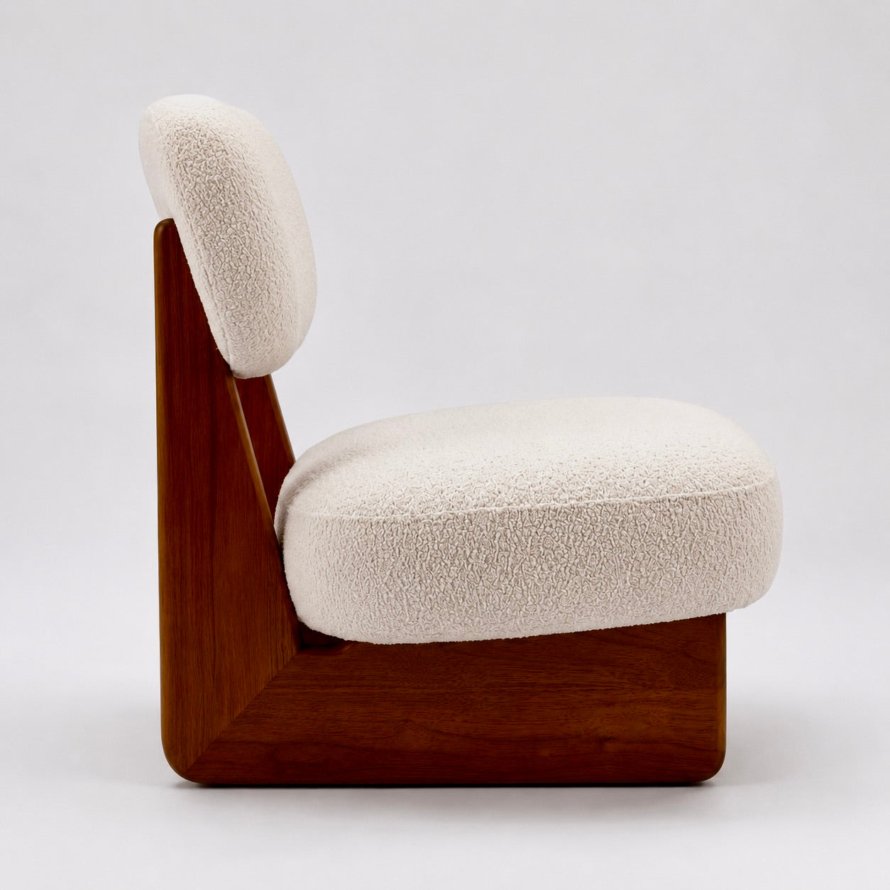 Boucle lounge chair side profile sculptural walnut base silhouette